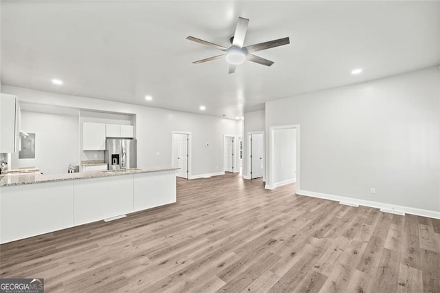 unfurnished living room featuring light hardwood / wood-style flooring and ceiling fan