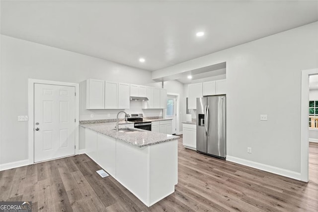 kitchen featuring white cabinetry, stainless steel appliances, kitchen peninsula, and light stone counters