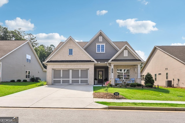 craftsman inspired home featuring a garage, a front lawn, and central air condition unit