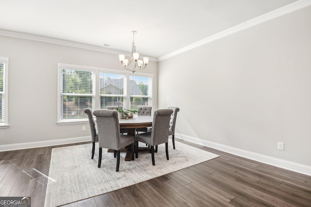 dining area with crown molding, dark hardwood / wood-style floors, and an inviting chandelier