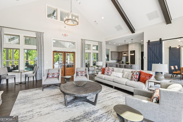 living room with an inviting chandelier, high vaulted ceiling, dark hardwood / wood-style floors, a barn door, and beamed ceiling