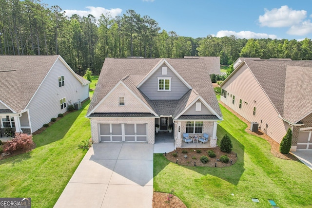 view of front facade with a garage, central AC, a front yard, and a patio area