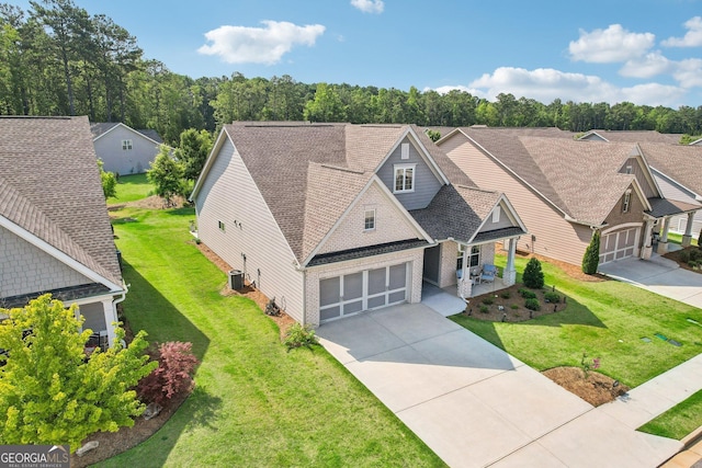 view of front of house with a garage, central air condition unit, and a front lawn