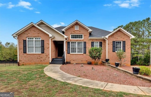 view of front of home with crawl space, brick siding, fence, and a front yard