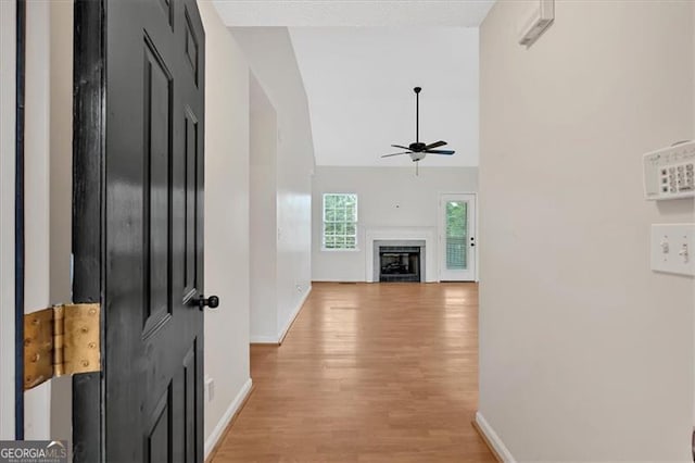 corridor featuring high vaulted ceiling and light wood-type flooring