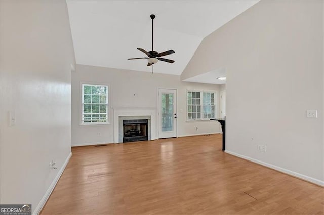 unfurnished living room featuring light wood finished floors, a fireplace, and a wealth of natural light