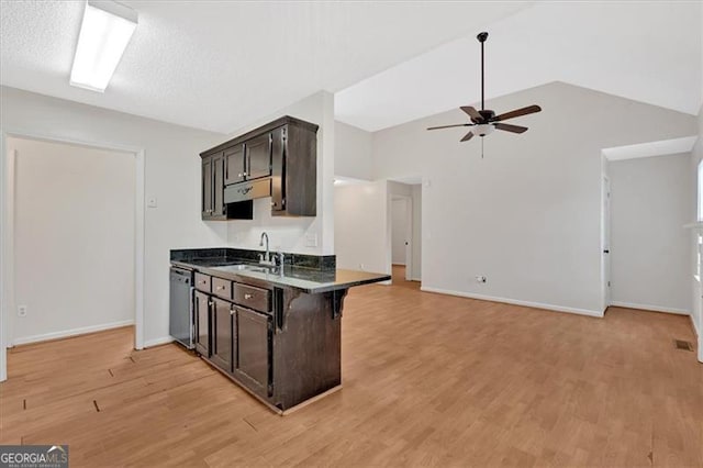 kitchen with dark brown cabinetry, lofted ceiling, a breakfast bar, sink, and stainless steel dishwasher