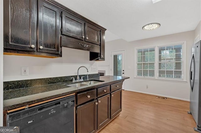 kitchen with black dishwasher, dark stone countertops, stainless steel fridge, sink, and dark brown cabinets