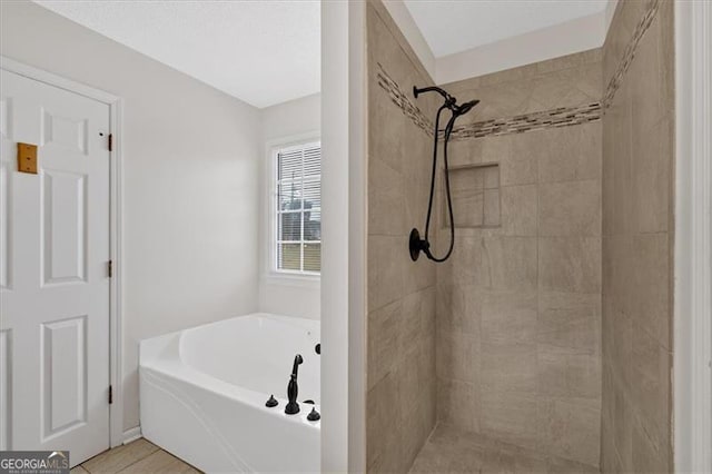 bathroom featuring tiled shower and a bath