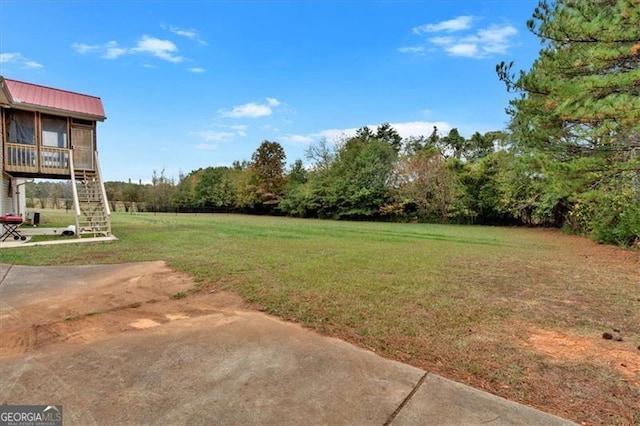 view of yard with a sunroom and stairs