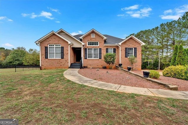 view of front of property featuring brick siding, a front yard, and fence