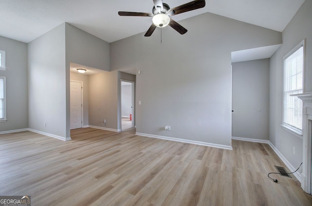 interior space featuring light wood-style floors, baseboards, visible vents, and high vaulted ceiling