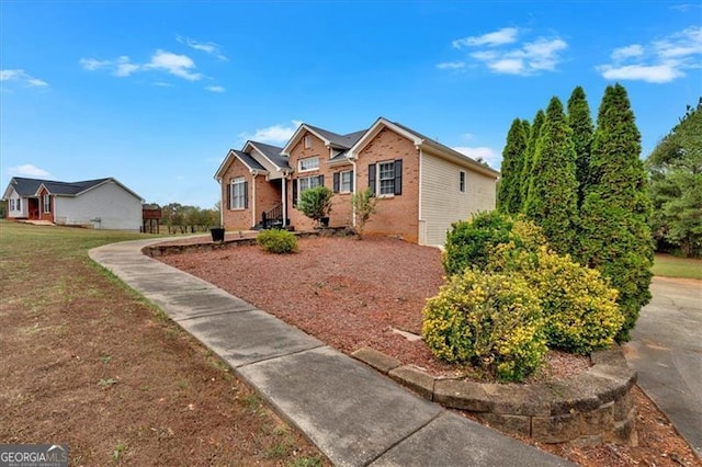 view of front facade with brick siding and a front lawn