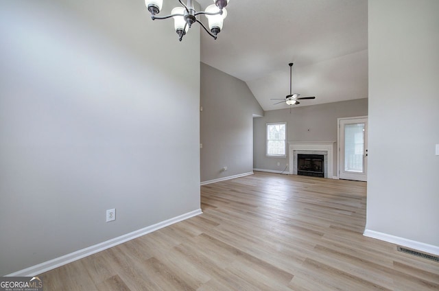 unfurnished living room featuring light wood-style floors, ceiling fan with notable chandelier, baseboards, and a high end fireplace