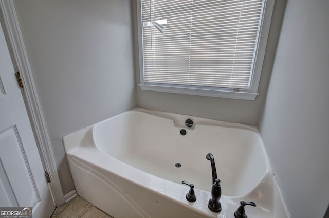 bathroom with plenty of natural light and a bath