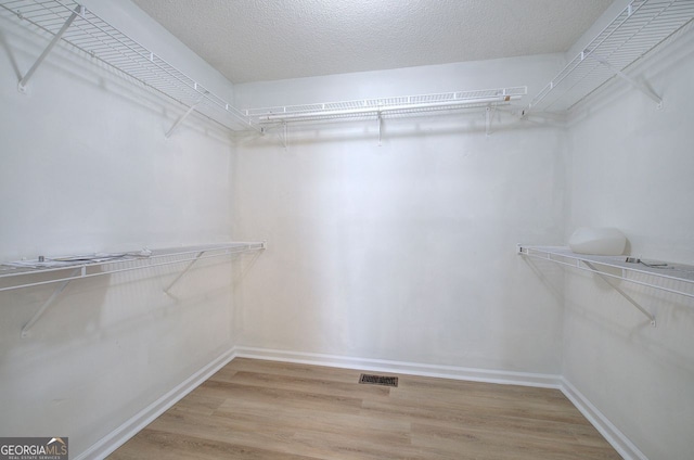 spacious closet with wood finished floors and visible vents