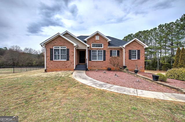 view of front of property with a front yard, brick siding, and fence