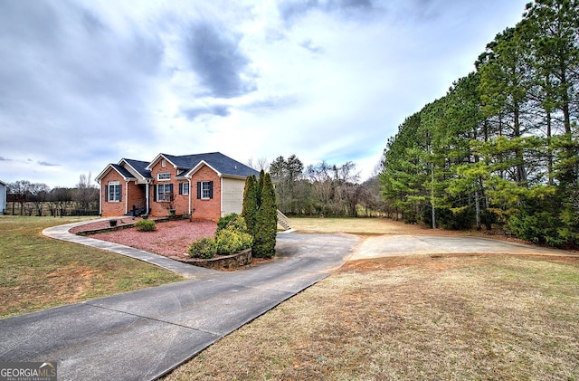 view of front of home featuring driveway, a front lawn, and brick siding