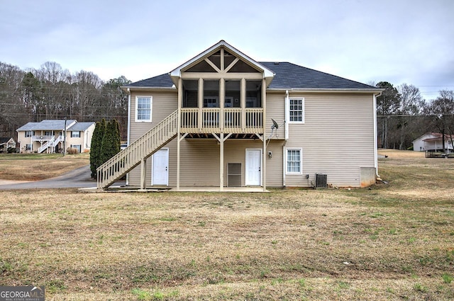 rear view of property featuring central air condition unit, a sunroom, stairs, a yard, and a patio area