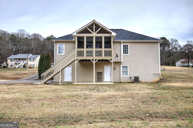 rear view of property with a patio, a sunroom, stairs, a yard, and central air condition unit