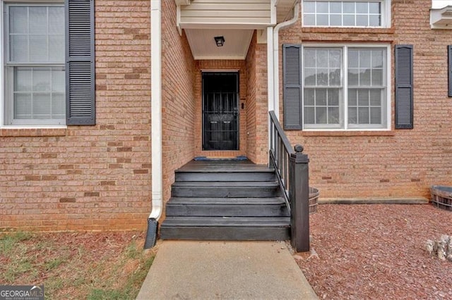 doorway to property featuring brick siding