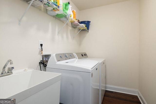 washroom featuring dark hardwood / wood-style flooring, sink, and washer and dryer