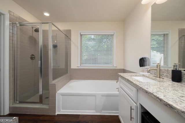 bathroom featuring hardwood / wood-style flooring, vanity, and separate shower and tub