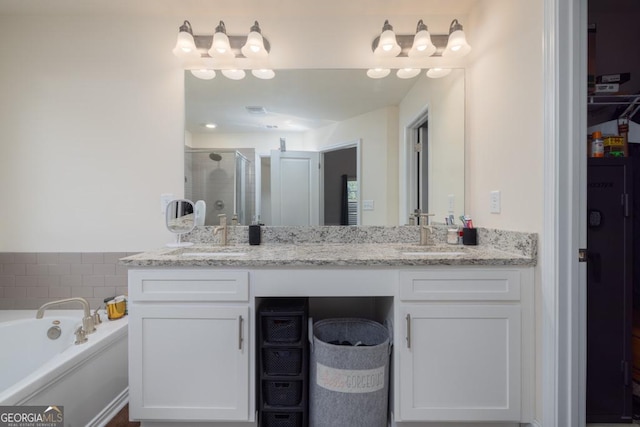 bathroom with vanity and shower with separate bathtub