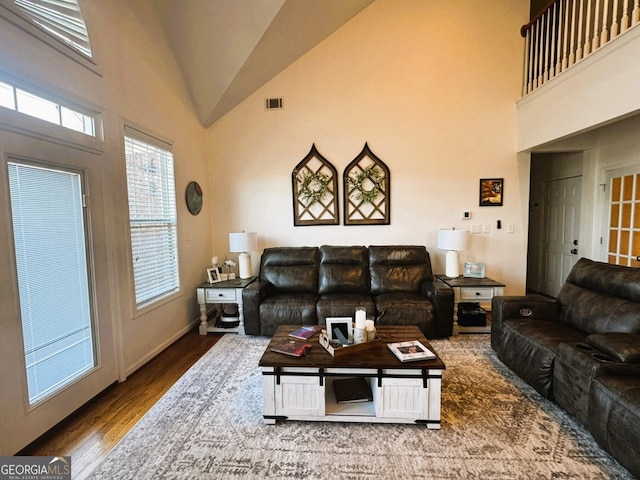 living room featuring high vaulted ceiling and hardwood / wood-style floors