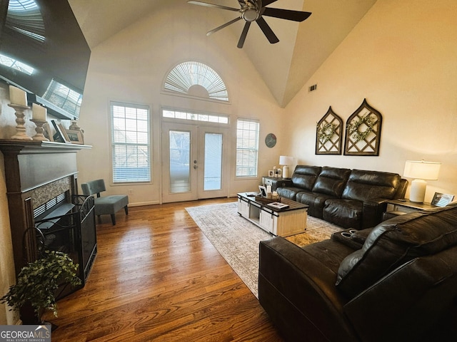 living room with hardwood / wood-style floors, high vaulted ceiling, french doors, and ceiling fan