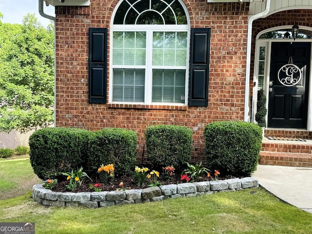 view of exterior entry with a lawn