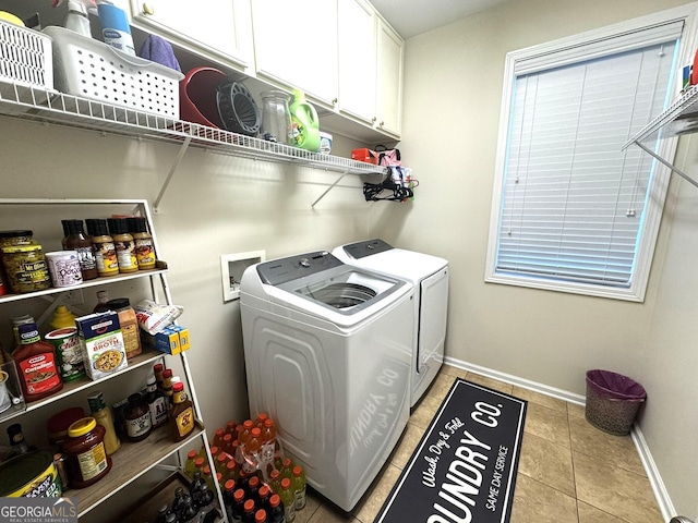 clothes washing area featuring cabinets, washing machine and clothes dryer, and light tile patterned flooring