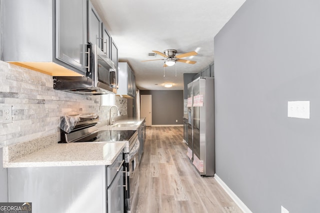 kitchen with tasteful backsplash, sink, gray cabinets, and appliances with stainless steel finishes