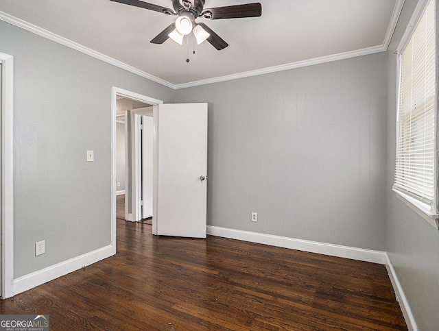 unfurnished bedroom featuring ornamental molding, dark wood-type flooring, a ceiling fan, and baseboards