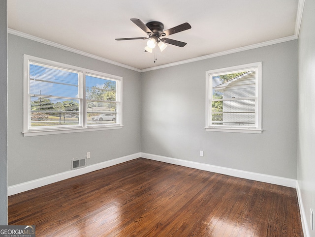spare room with a wealth of natural light, visible vents, and crown molding