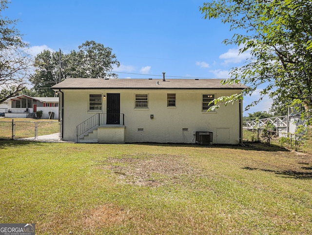 rear view of house with cooling unit, fence, crawl space, a lawn, and a gate
