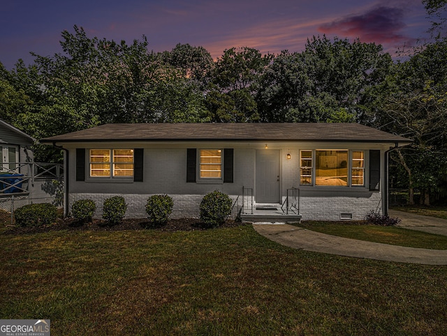 view of front of property featuring crawl space, a front yard, and brick siding