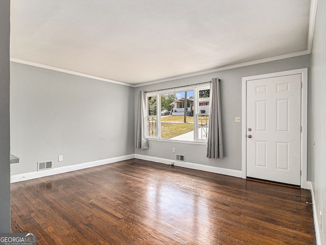 unfurnished room with ornamental molding, wood finished floors, visible vents, and baseboards