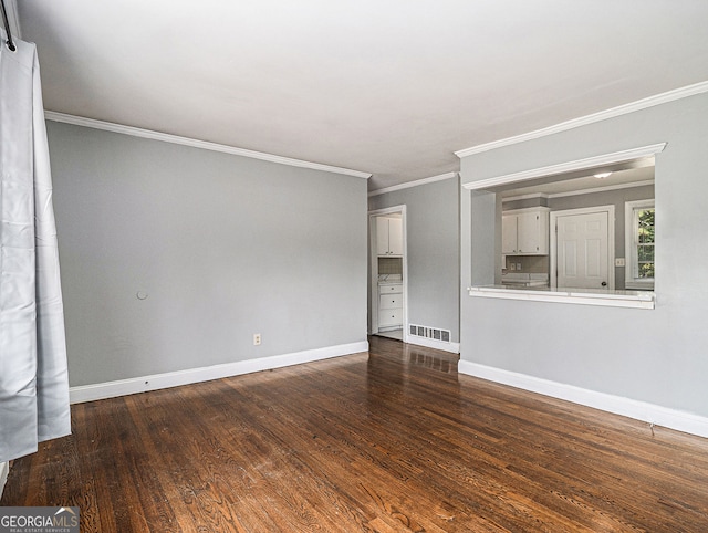 unfurnished living room featuring crown molding, wood finished floors, visible vents, and baseboards