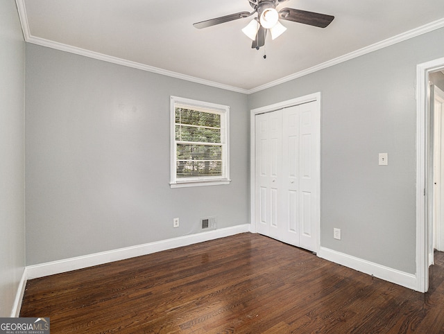unfurnished bedroom with dark wood-style floors, visible vents, crown molding, and baseboards