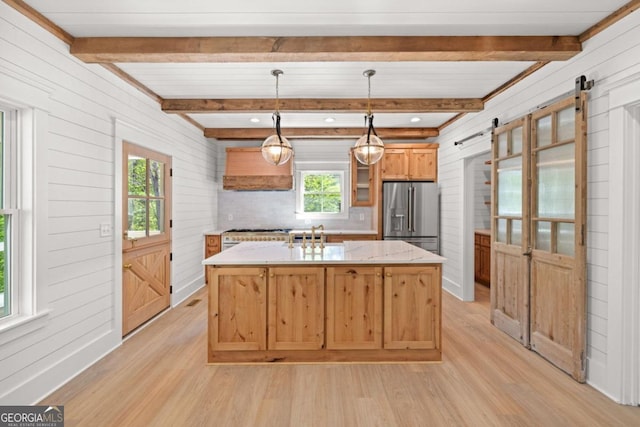 4226 Quail Creek Dr, Flowery Branch, GA 30542 - kitchen with appliances with stainless steel finishes, a barn door, premium range hood, light wood finished floors, and wood walls