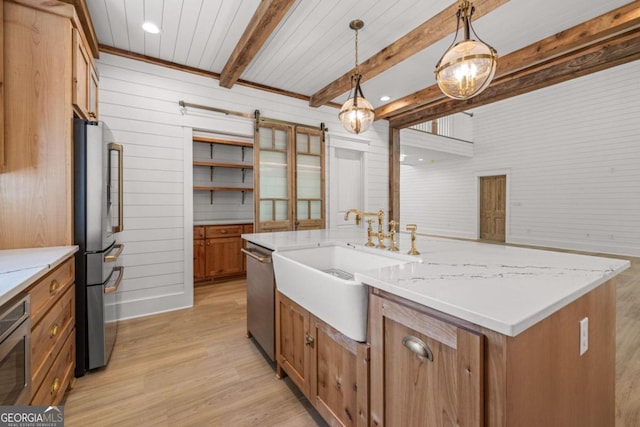 kitchen with appliances with stainless steel finishes, decorative light fixtures, sink, light wood-type flooring, and beam ceiling