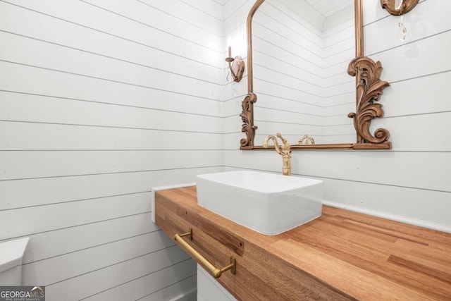 bathroom featuring vanity and wood walls