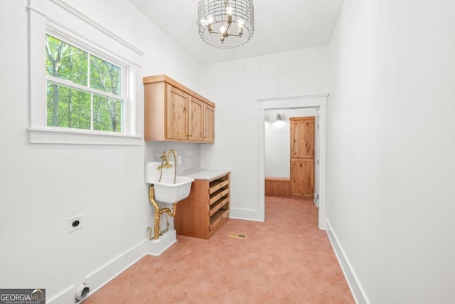 4226 Quail Creek Dr, Flowery Branch, GA 30542 - laundry area with cabinet space, hookup for a gas dryer, hookup for an electric dryer, a chandelier, and light flooring