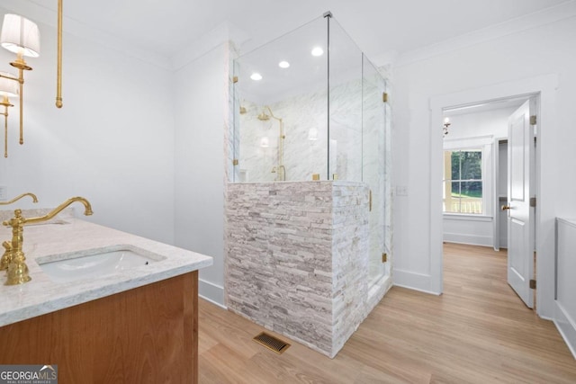 bathroom with crown molding, vanity, an enclosed shower, and hardwood / wood-style floors