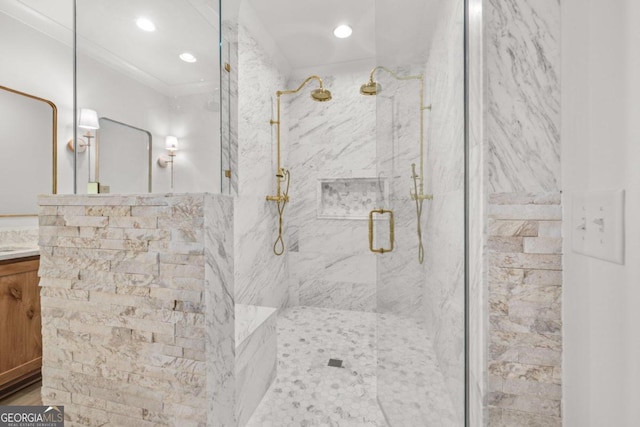 bathroom with ornamental molding, vanity, and a shower with shower door