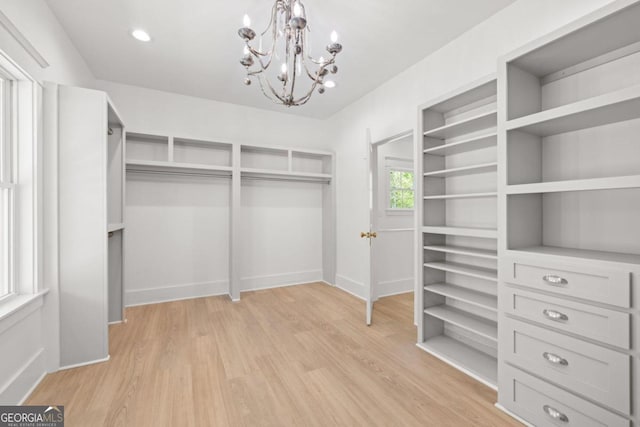 walk in closet featuring a chandelier and light hardwood / wood-style floors