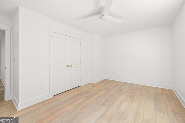 unfurnished bedroom with light hardwood / wood-style flooring, a closet, and ceiling fan