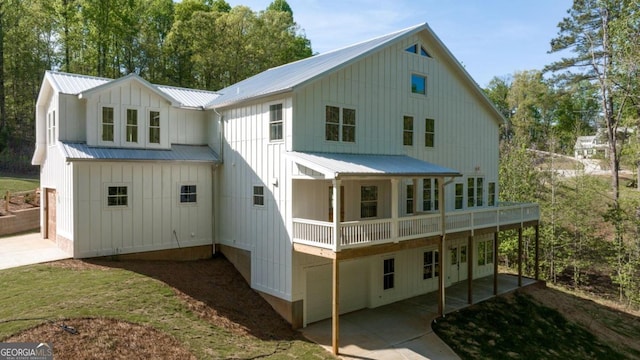 4226 Quail Creek Dr, Flowery Branch, GA 30542 - back of property featuring board and batten siding, a metal roof, a patio, driveway, and a wooden deck