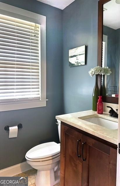 bathroom featuring tile patterned flooring, vanity, and toilet